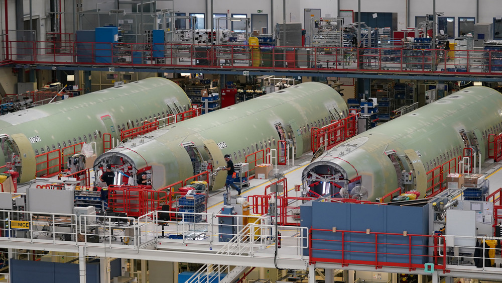Airbus-Mitarbeiter arbeiten in einer Halle auf dem Airbus-Werksgelände in Hamburg an A320-Flugzeugrümpfen. 