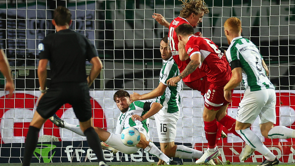 Münsters Dominik Schad (2.v.l) kommt zu spät gegen den Torschuss von Stuttgarts Torschützen Angelo Stiller (2.v.r) zum 0:1.