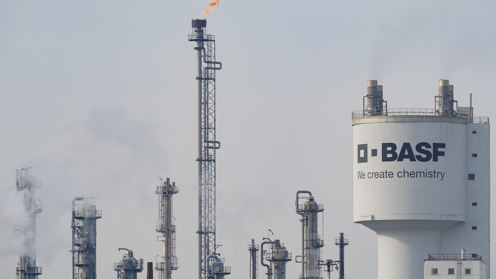 Ein Turm mit der Aufschrift „BASF“ steht neben Schornsteinen auf dem Werksgelände des Chemiekonzerns BASF.